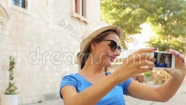戴帽子戴太阳镜的女孩用智能手机自拍